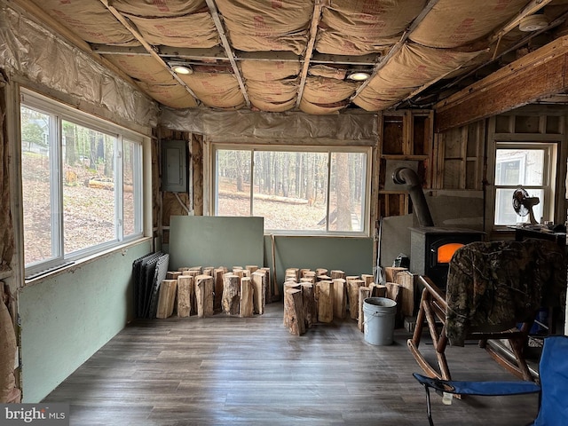 misc room featuring dark hardwood / wood-style floors, a wood stove, and electric panel