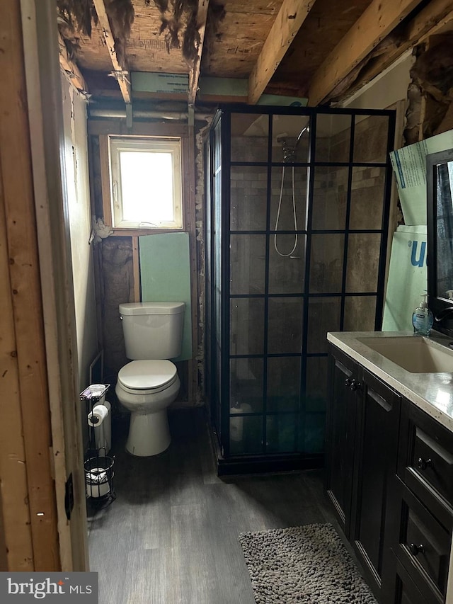 bathroom with beamed ceiling, hardwood / wood-style floors, vanity, and toilet