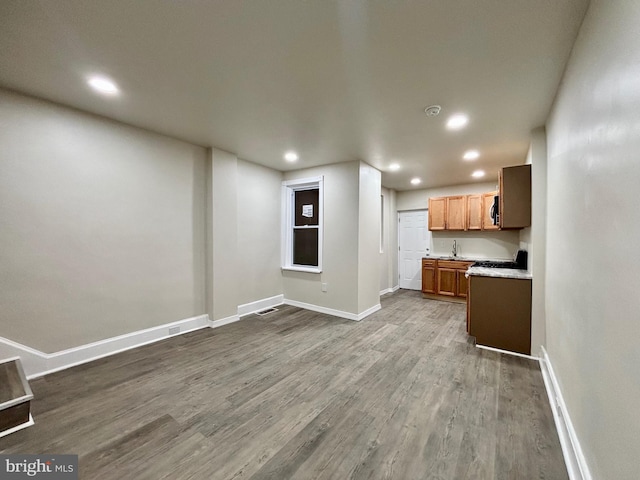 unfurnished living room with hardwood / wood-style floors and sink