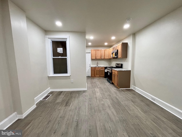 kitchen with wood-type flooring, stainless steel appliances, and sink