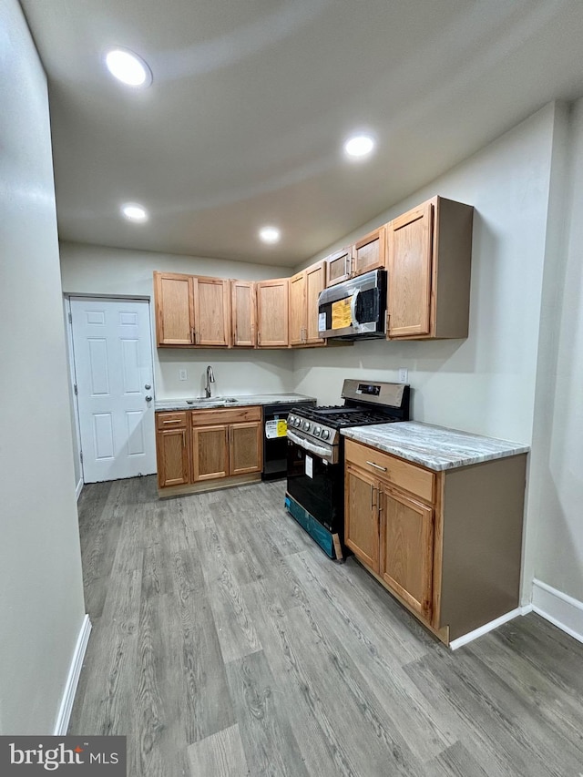 kitchen with sink, black range with gas cooktop, and light hardwood / wood-style flooring