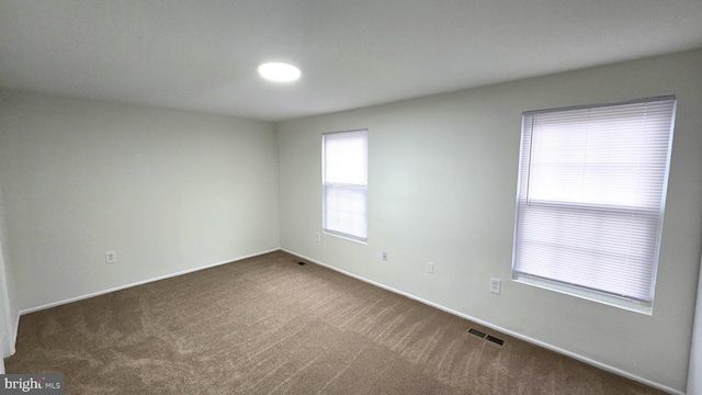 empty room with dark colored carpet