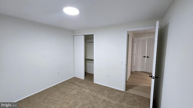 unfurnished bedroom with a closet and light colored carpet