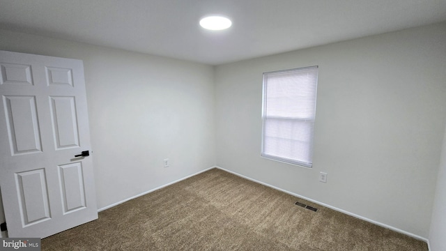 unfurnished room with dark carpet