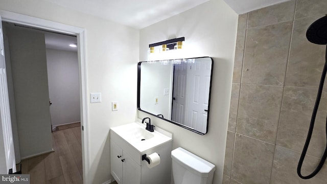 bathroom with wood-type flooring, vanity, and toilet