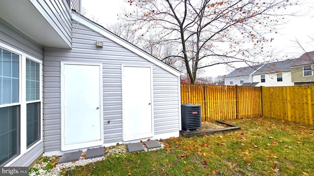 view of outbuilding with a lawn and central air condition unit