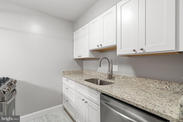 kitchen with light stone counters, sink, white cabinets, and appliances with stainless steel finishes