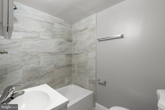 full bathroom featuring tiled shower / bath combo, toilet, and sink