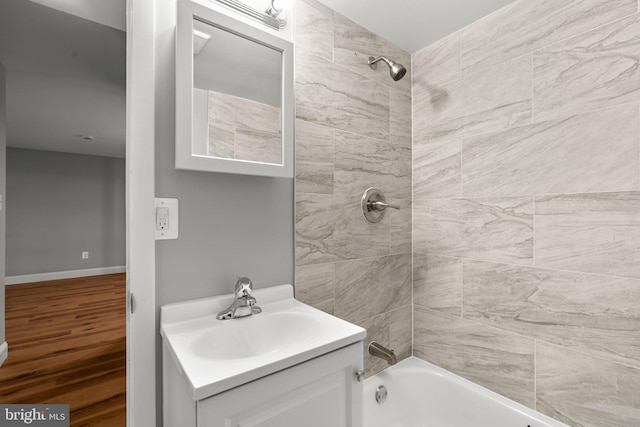 bathroom featuring vanity, tiled shower / bath combo, and hardwood / wood-style flooring