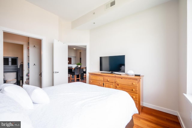 bedroom featuring ensuite bathroom and hardwood / wood-style flooring