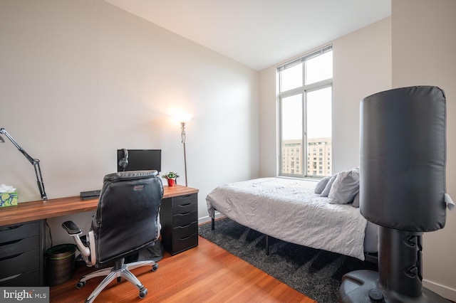 bedroom with hardwood / wood-style floors and lofted ceiling