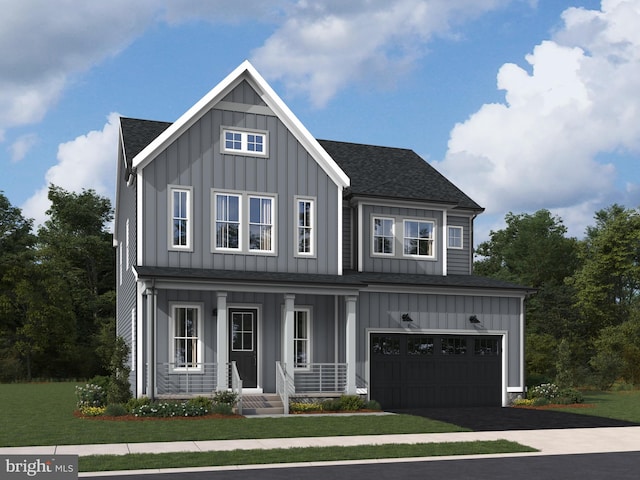 view of front of home featuring covered porch, a front yard, and a garage