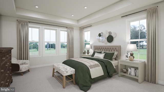 bedroom with a tray ceiling and light carpet