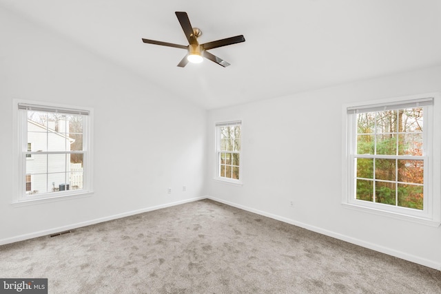 carpeted spare room with ceiling fan, lofted ceiling, and a wealth of natural light