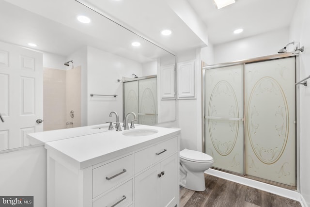 bathroom with walk in shower, toilet, vanity, and hardwood / wood-style flooring