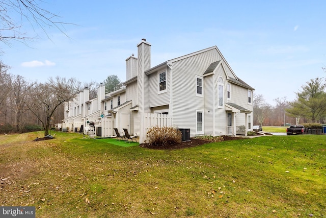 view of side of property with cooling unit and a yard