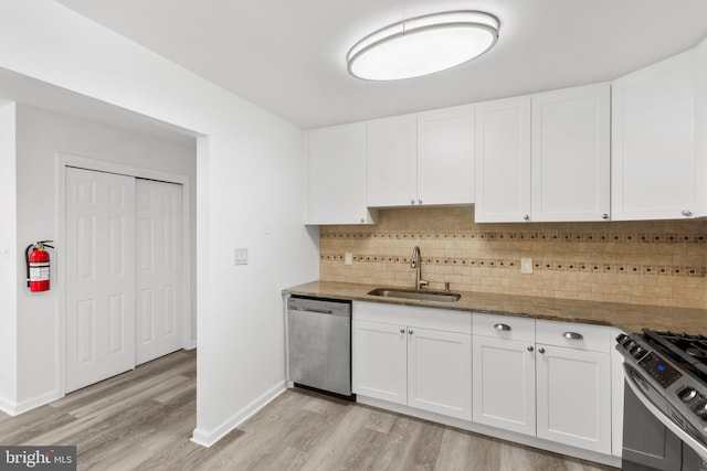 kitchen with white cabinetry, sink, stainless steel appliances, and light hardwood / wood-style flooring