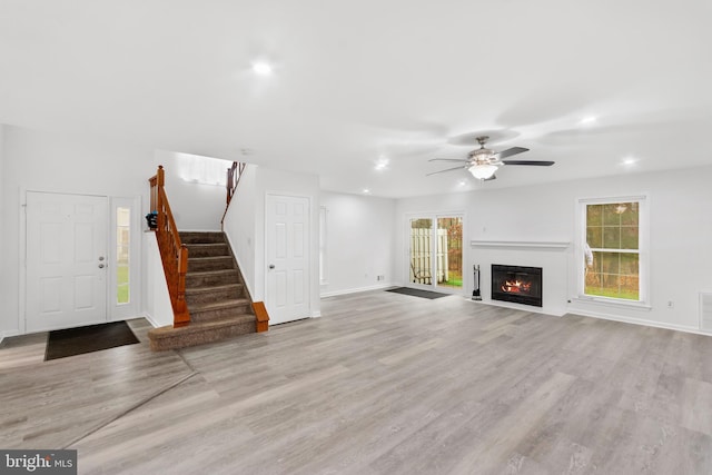 unfurnished living room with light hardwood / wood-style flooring and ceiling fan