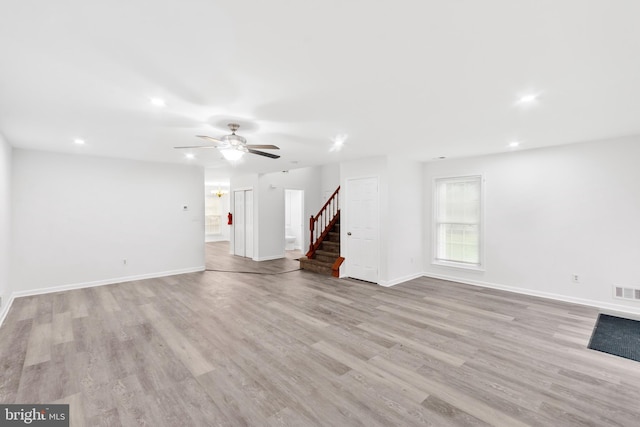 unfurnished living room featuring ceiling fan and light wood-type flooring