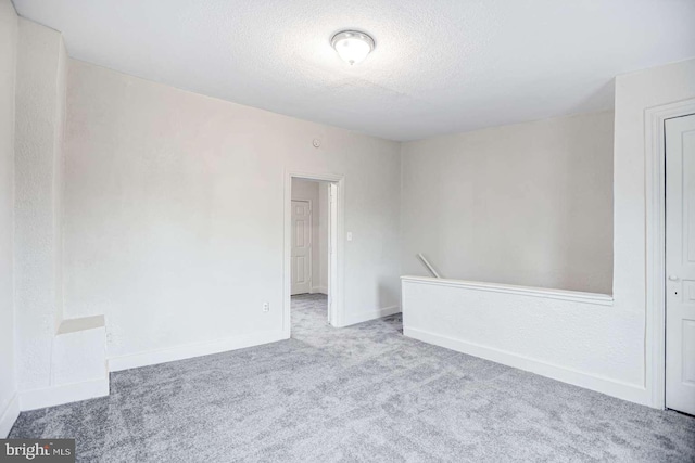 unfurnished room with light carpet and a textured ceiling