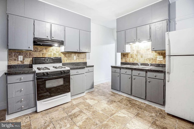 kitchen with backsplash, gray cabinetry, sink, and white appliances