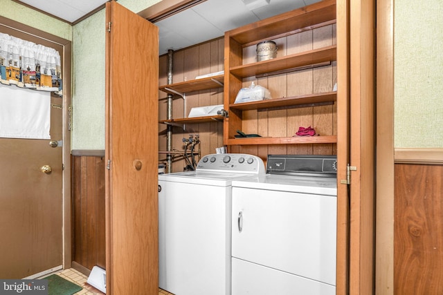 laundry area with wood walls and washer and dryer