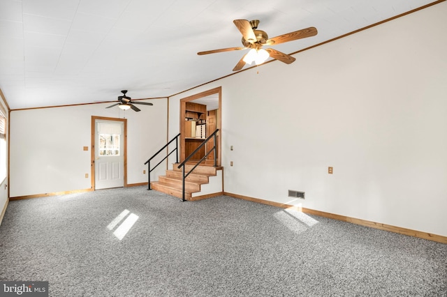 carpeted spare room with ceiling fan, vaulted ceiling, and ornamental molding