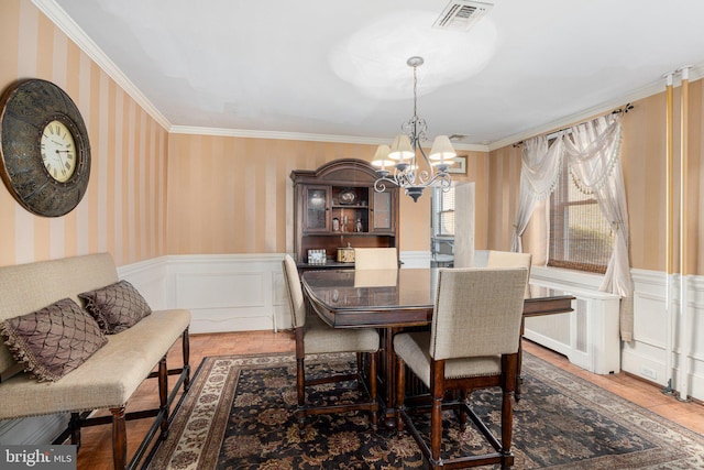 dining area with a chandelier, radiator heating unit, and ornamental molding