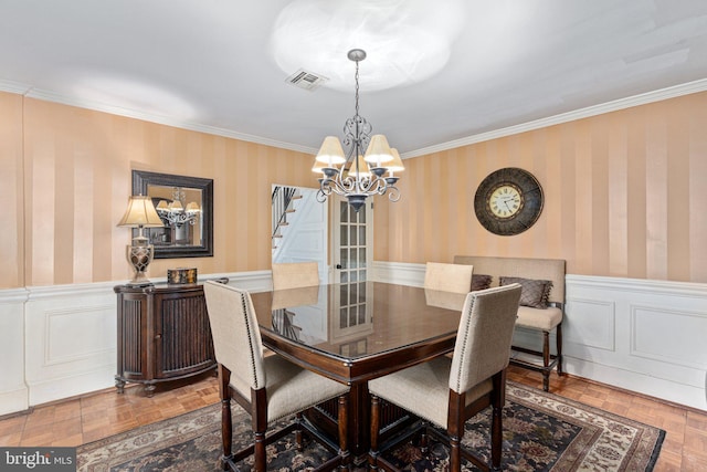 dining space featuring ornamental molding, a notable chandelier, and parquet flooring