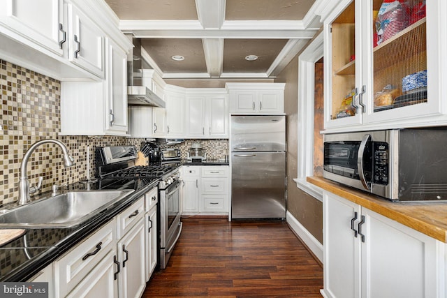 kitchen with appliances with stainless steel finishes, backsplash, sink, beamed ceiling, and white cabinets