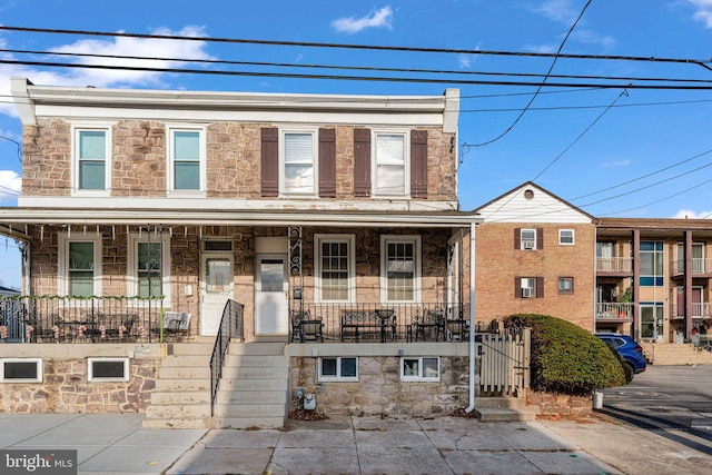 townhome / multi-family property featuring covered porch