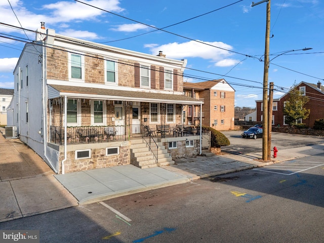 townhome / multi-family property with central AC unit and a porch