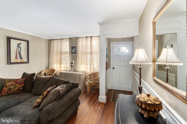 living room with decorative columns, dark wood-type flooring, and ornamental molding