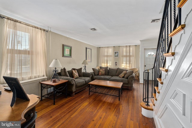 living room with crown molding and dark wood-type flooring