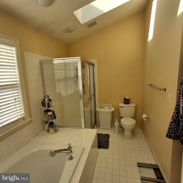 bathroom with tile patterned flooring, toilet, separate shower and tub, and a skylight