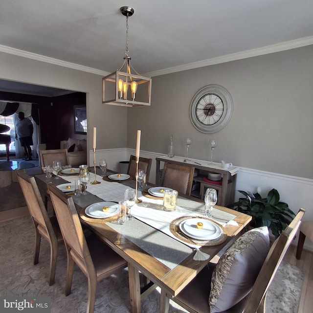 dining room featuring hardwood / wood-style flooring, ornamental molding, and an inviting chandelier