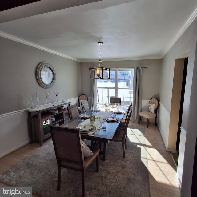 dining room with crown molding and light hardwood / wood-style floors