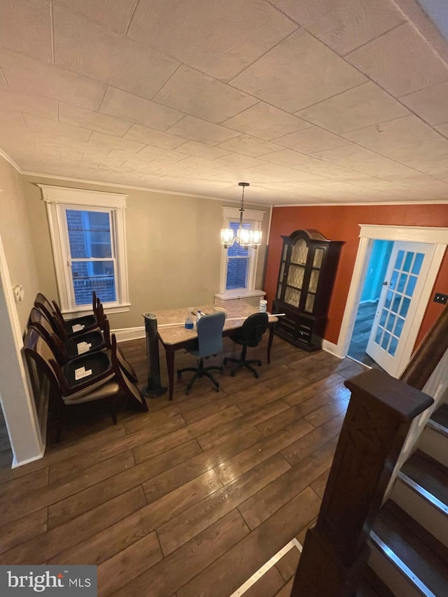 dining room featuring ornamental molding, dark wood-type flooring, and an inviting chandelier