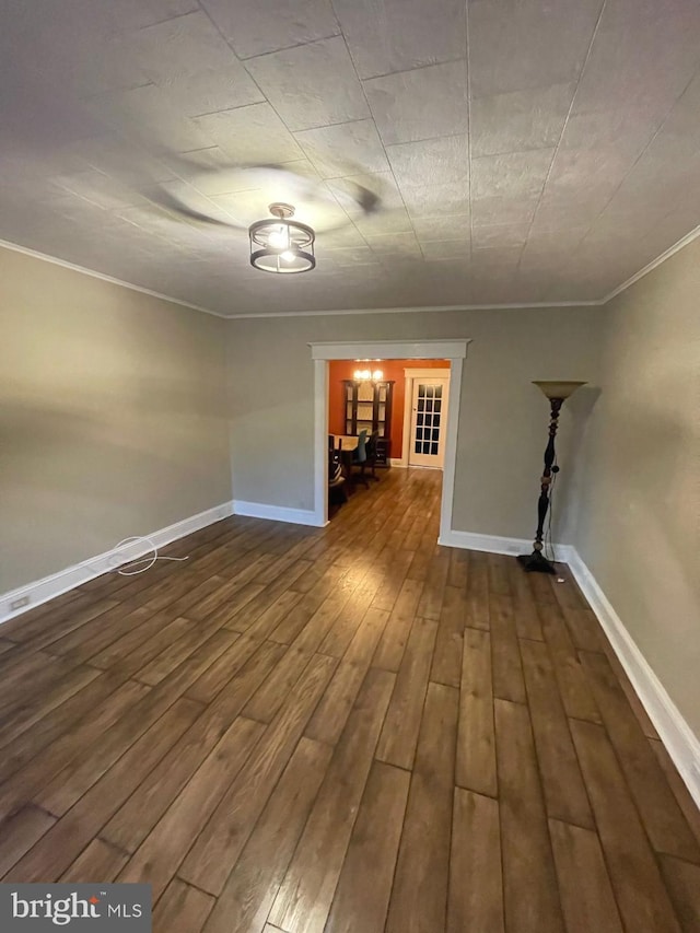 empty room featuring wood-type flooring and ornamental molding