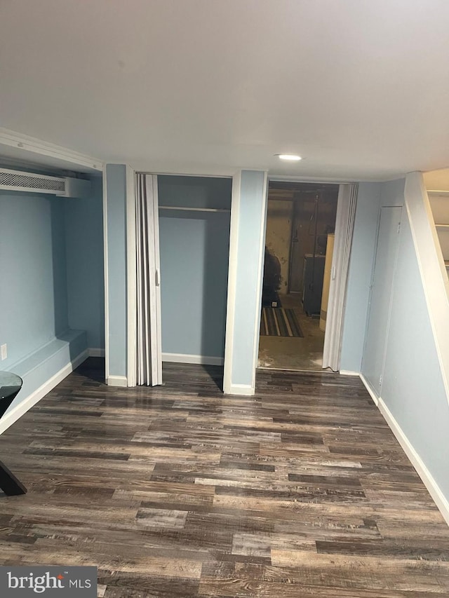 unfurnished bedroom featuring dark wood-type flooring and two closets