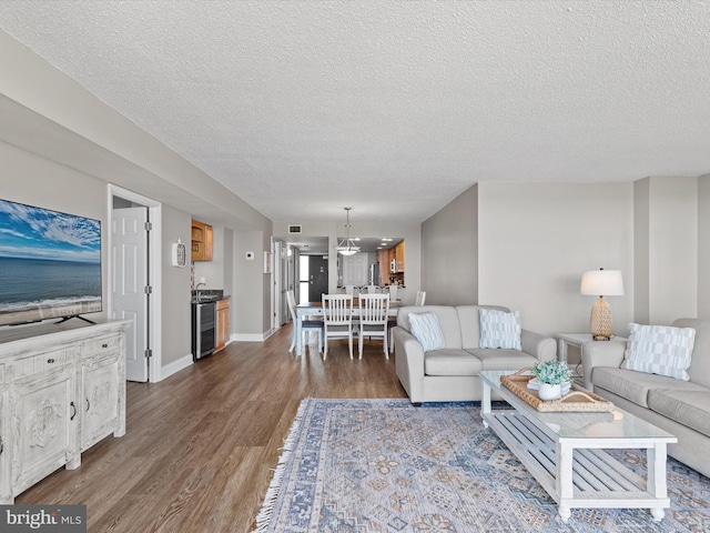 701 S Edgewater House Rd Unit 701S, Bethany Beach, DE 19930 - living room featuring dark wood-type flooring, a textured ceiling, and a chandelier