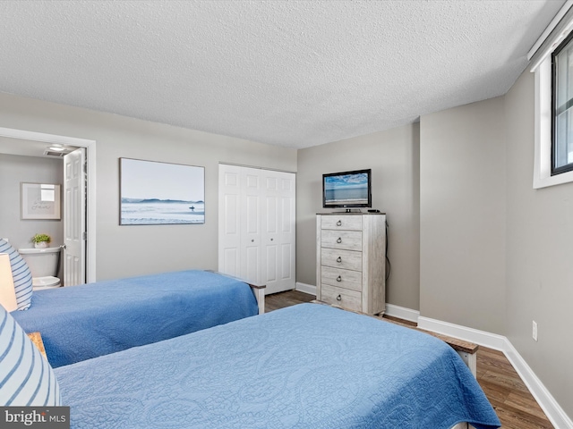 701 S Edgewater House Rd Unit 701S, Bethany Beach, DE 19930 - bedroom with wood finished floors, a closet, a textured ceiling, and ensuite bath
