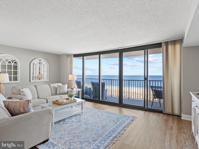 701 S Edgewater House Rd Unit 701S, Bethany Beach, DE 19930 - living area featuring a textured ceiling, light wood finished floors, a wall of windows, and a water view