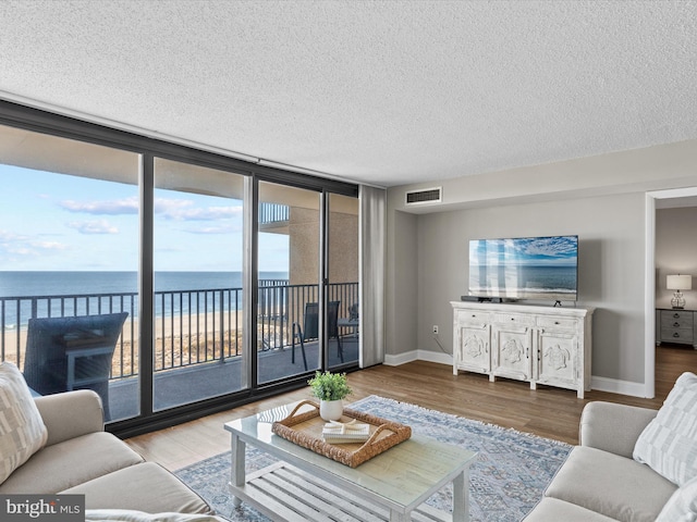 701 S Edgewater House Rd Unit 701S, Bethany Beach, DE 19930 - living room featuring wood finished floors, a textured ceiling, and floor to ceiling windows