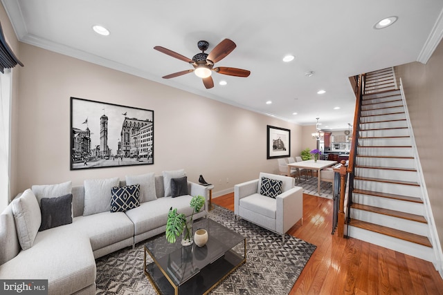 living room featuring hardwood / wood-style flooring, ceiling fan, and crown molding