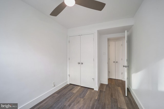 unfurnished bedroom with ceiling fan, dark wood-type flooring, and a closet