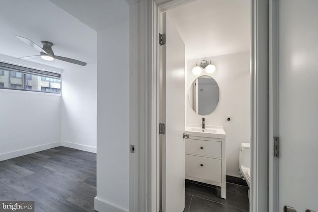 bathroom with toilet, ceiling fan, and vanity