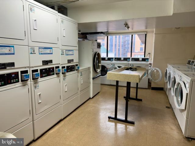 laundry area with stacked washer / dryer and washer and clothes dryer