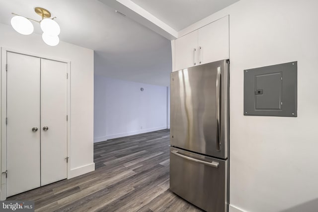 kitchen with white cabinets, dark hardwood / wood-style flooring, stainless steel refrigerator, and electric panel