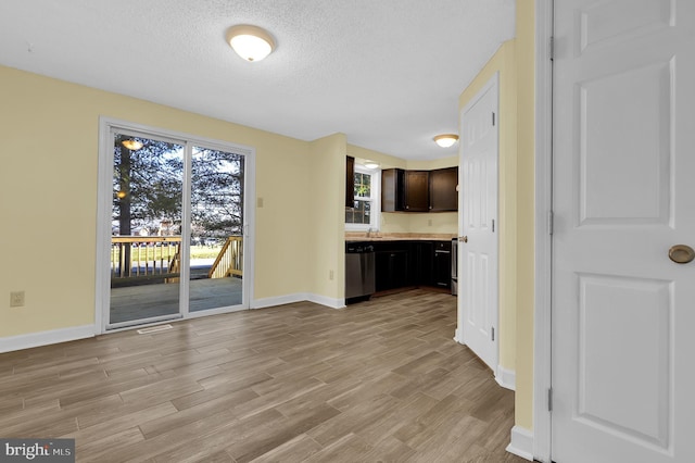 unfurnished living room featuring a textured ceiling and light hardwood / wood-style flooring